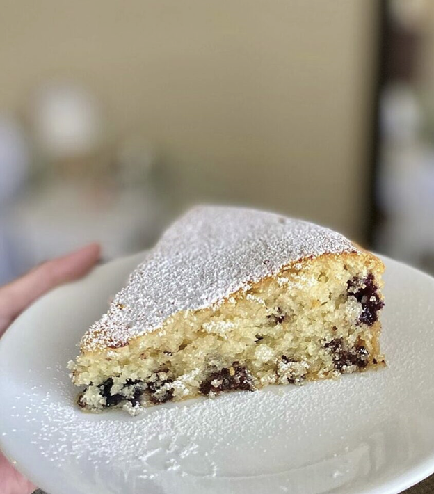 photo of a slice of blueberry muffin sprinkled with powdered sugar